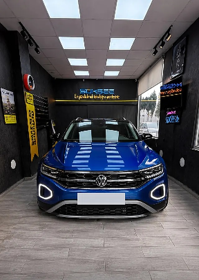 Mavi Volkswagen T-Roc, farları açık, Süksee dükkânında